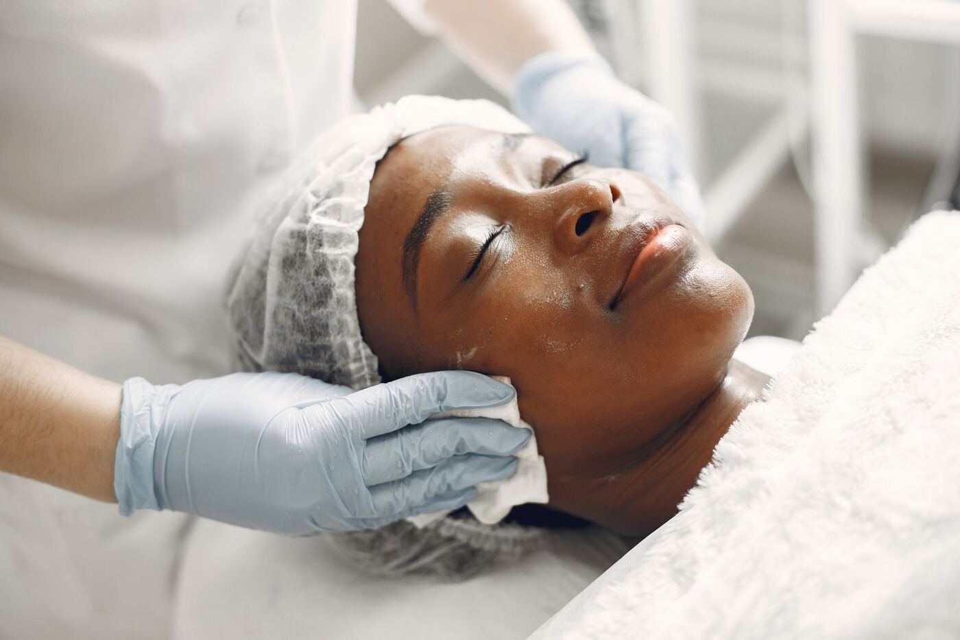Manos de la especialista realizando una limpieza facial suave